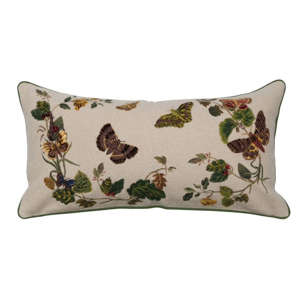 A rectangular cotton lumbar pillow with an embroidered butterfly and flower design on a beige mud cloth background, featuring green piping around the edges.